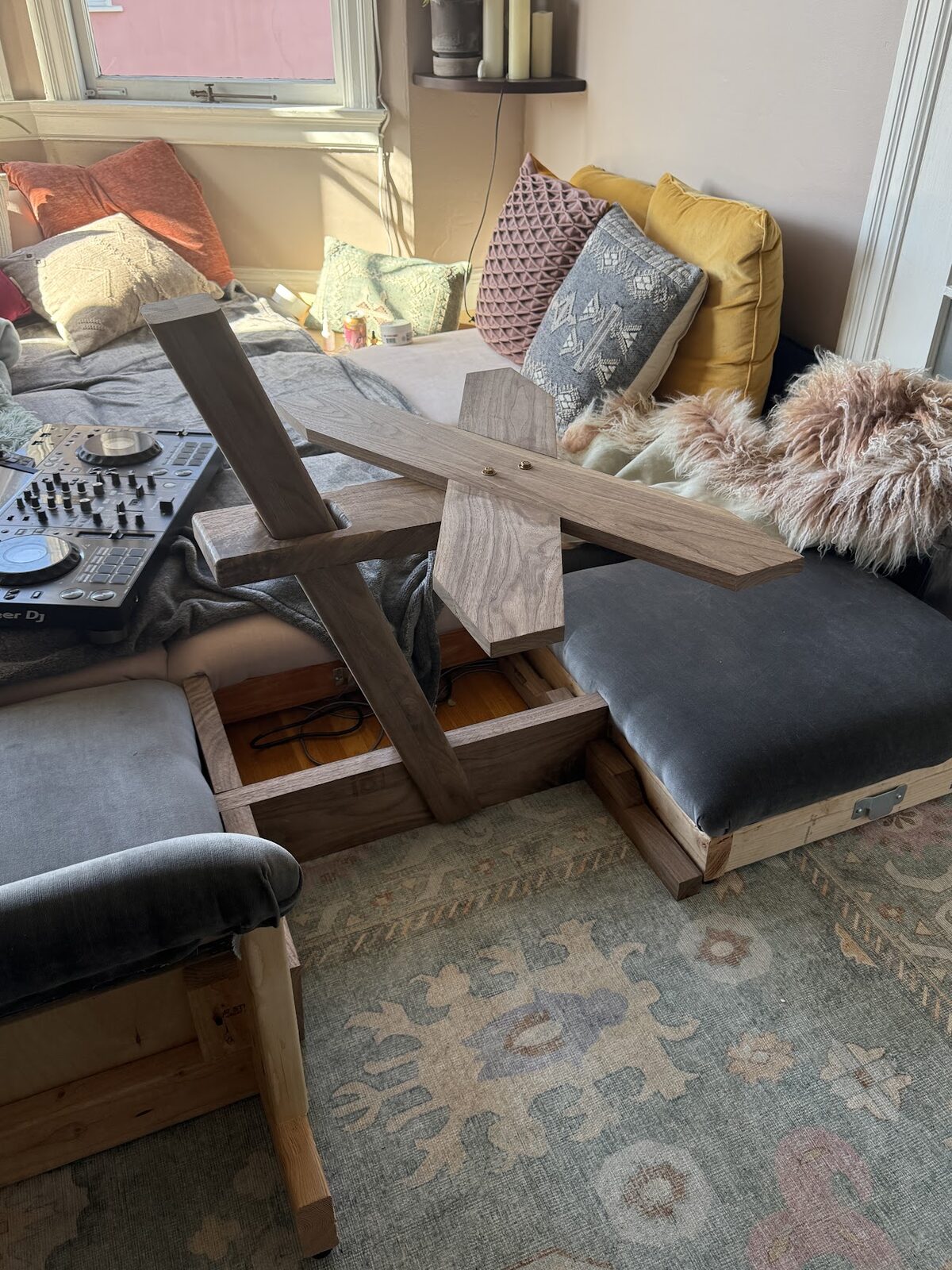 Hand-shaped walnut pedestal table beside the sectional